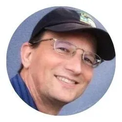 Person wearing a cap and glasses, smiling