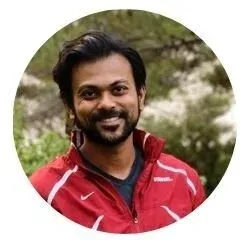 A man in a red jacket smiling outdoors