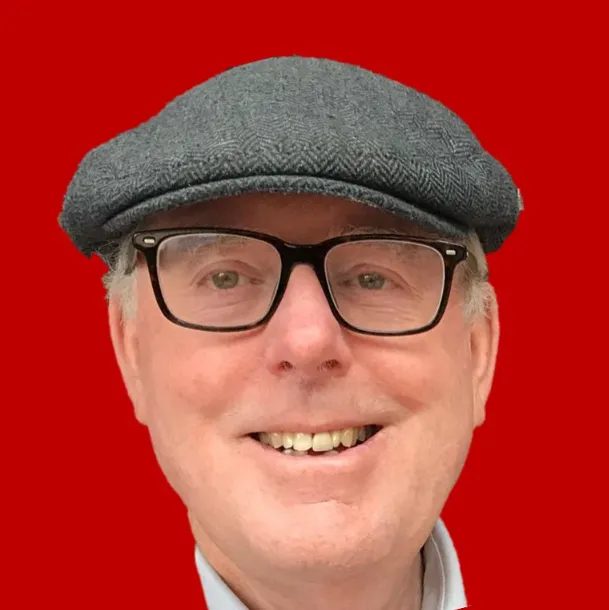Man wearing a flat cap and glasses with a red background.